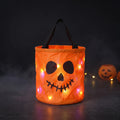 CandyGleam orange LED light-up Halloween candy bucket with smiling skull face